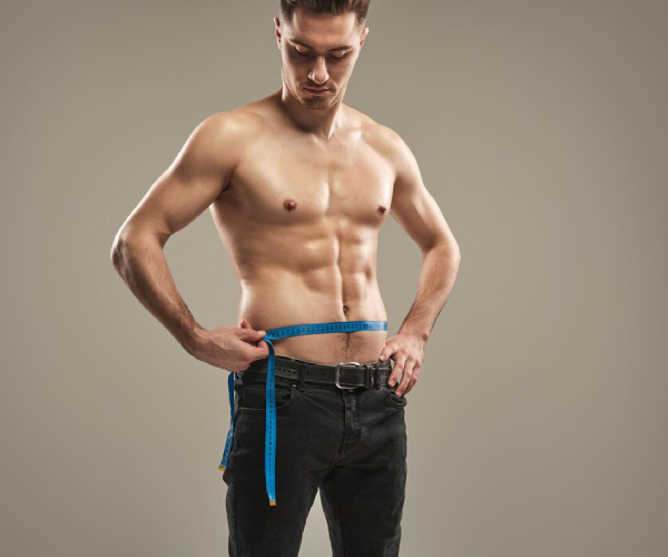Man measuring his waist with measuring tape